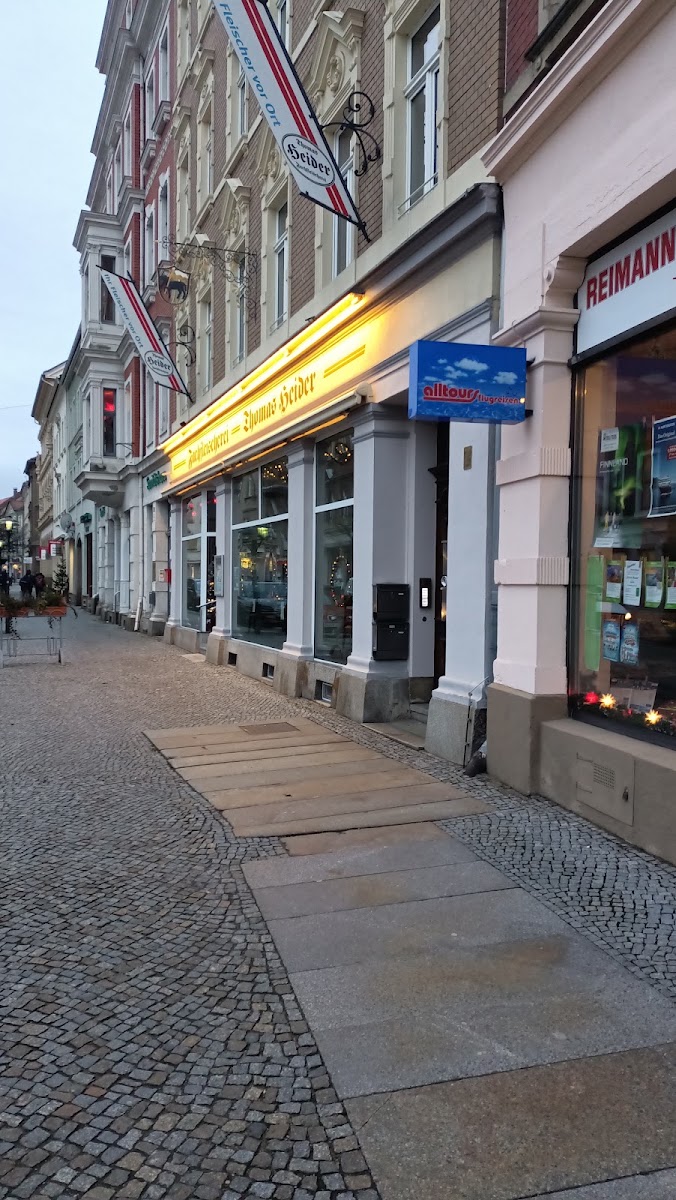 Fleischerei Heider am Abend, beleuchtetes Schaufenster